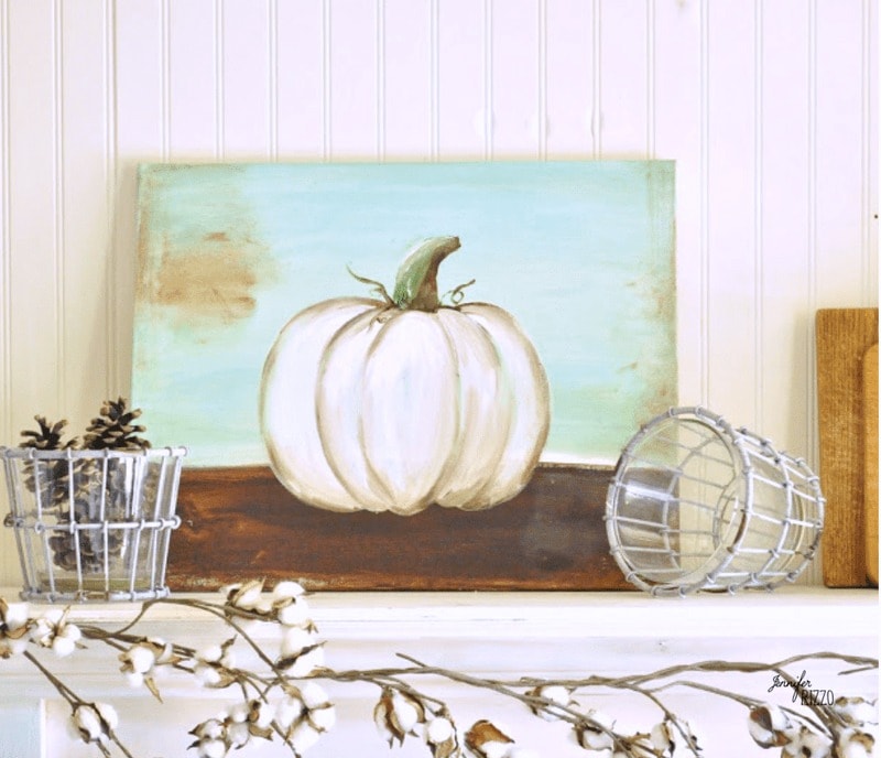 painting of white pumpkin on a fireplace mantel.
