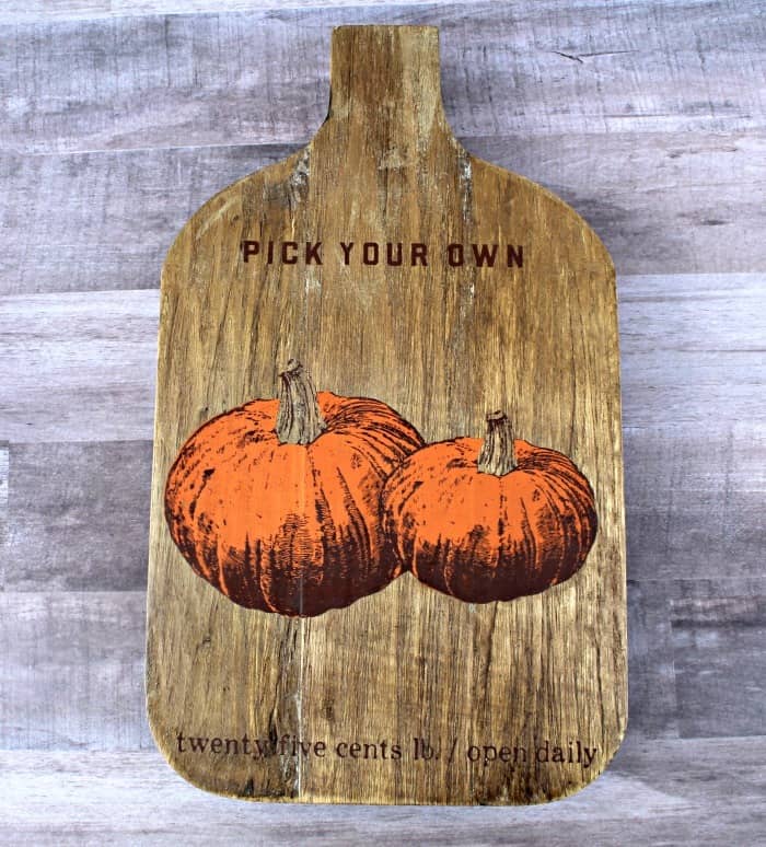 Wooden breadboard painted with pumpkins and turned into a trivet.