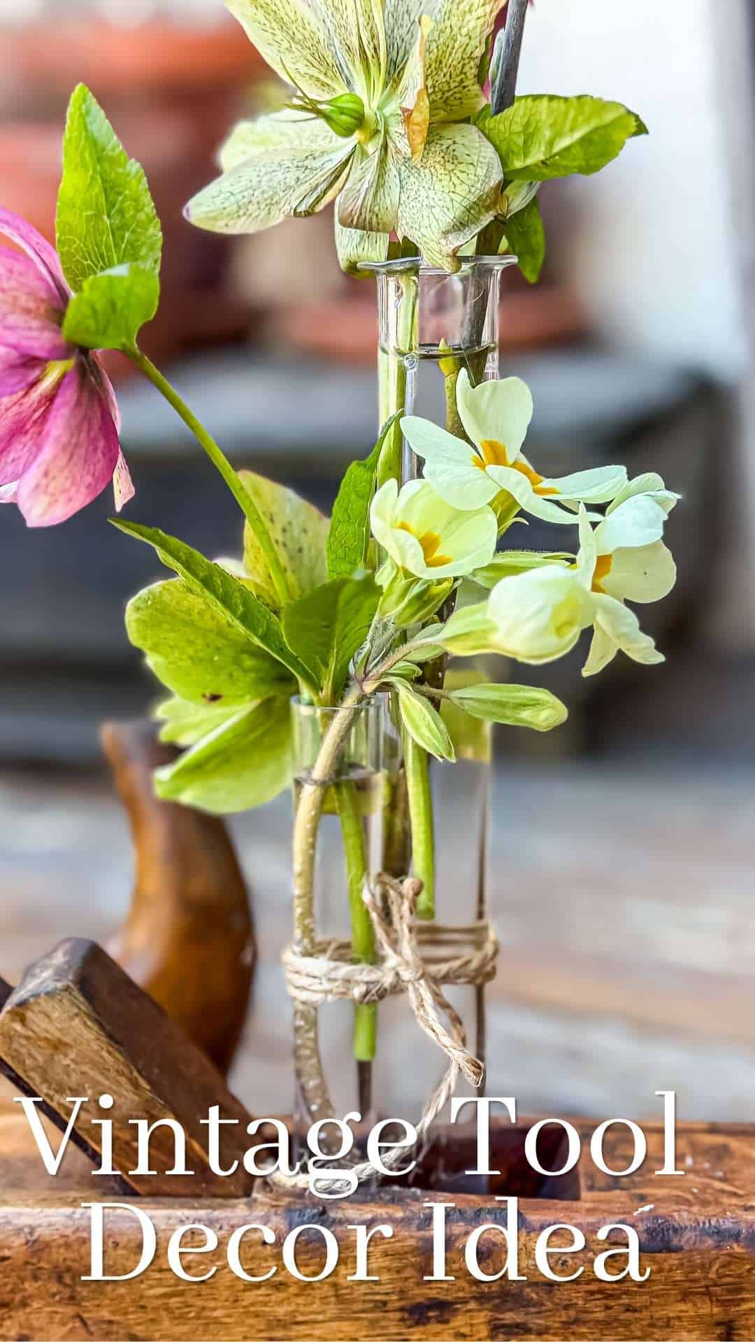 A flower arrangement inside a vintage wooden hand planer. Text overlay: Vintage tool decor idea.