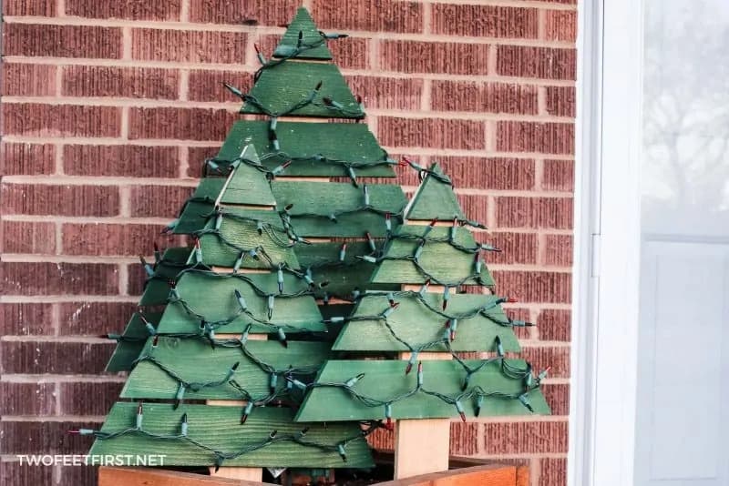 Three green painted Christmas tree with lights made from wood.