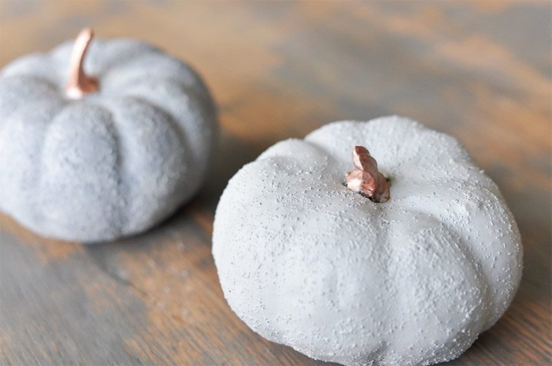 two diy concrete pumpkins on a table.