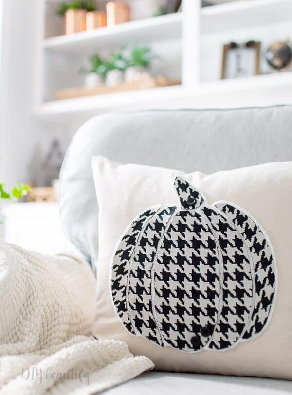 DIY fall pillow craft idea with black and white pumpkin on a white throw pillow.
