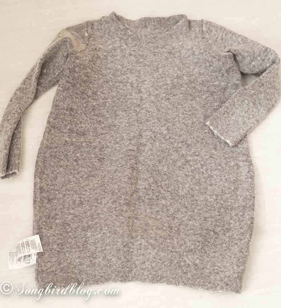 Grey wool dress that has shrunk and felted in the laundry laying on a white surface.