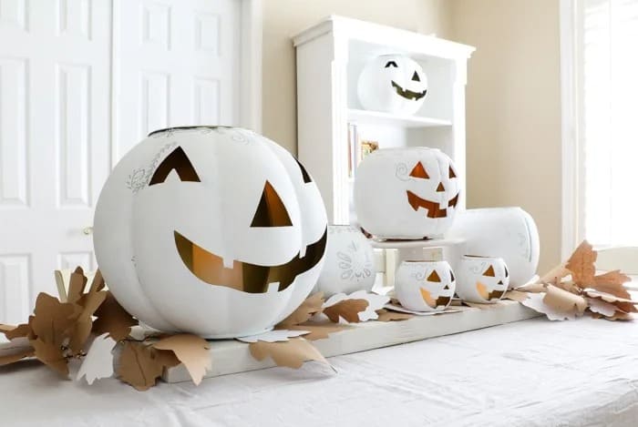 buffet table decorated with white and gold halloween jack o lanterns.