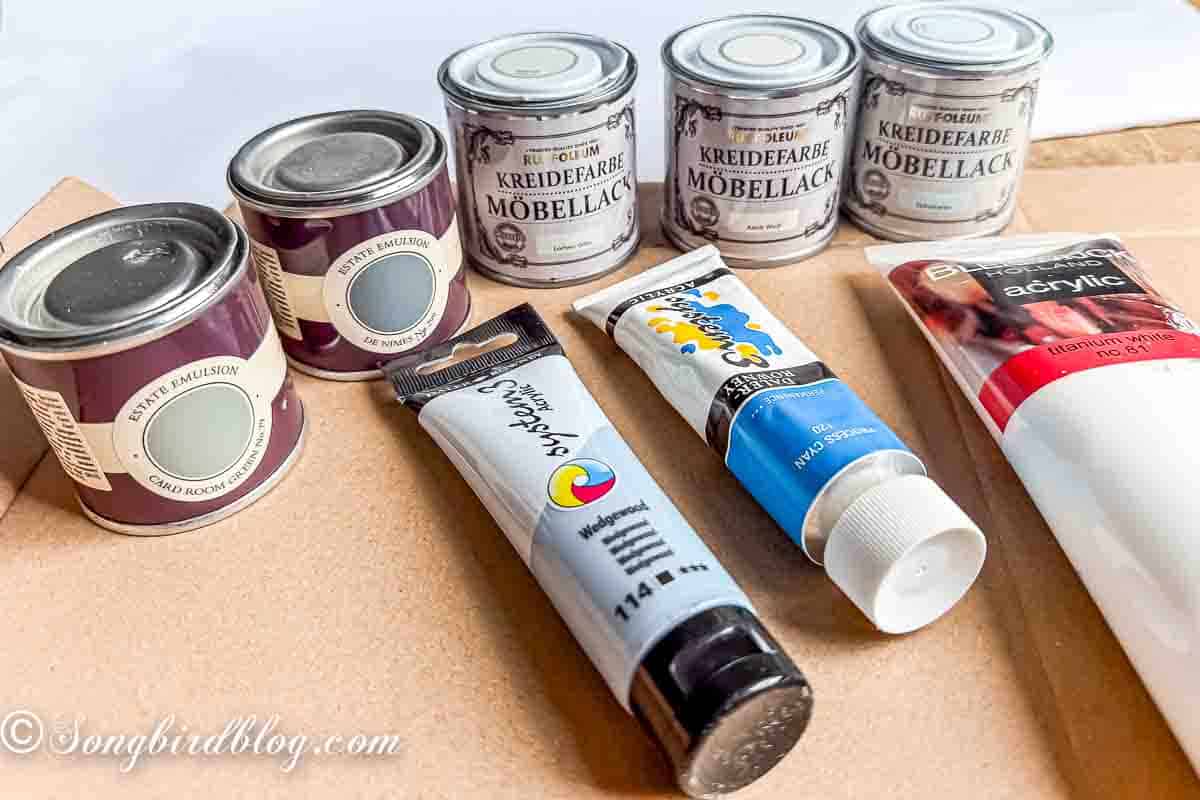 Collection of craft paints in tubes and pots.