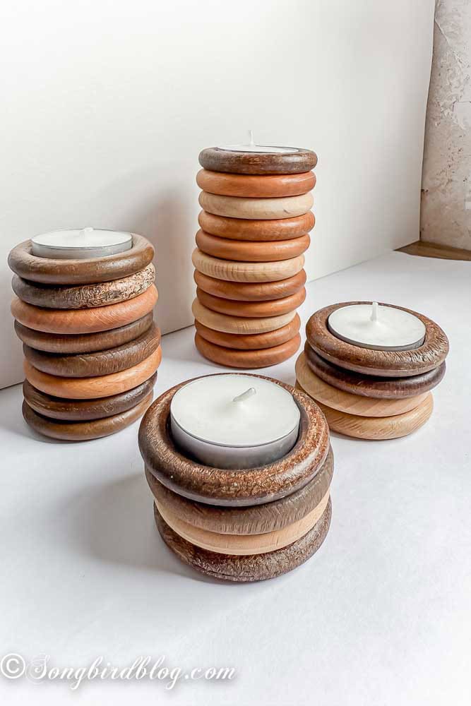 Stacked plain wooden curtain rings with a tea light on top.