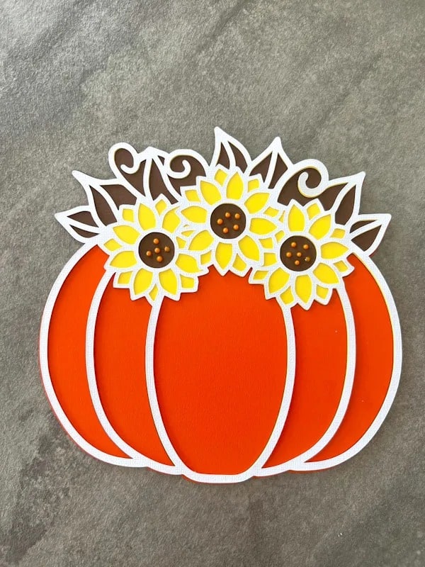 3D paper cutting SVG template for pumpkin with sunflowers on top.