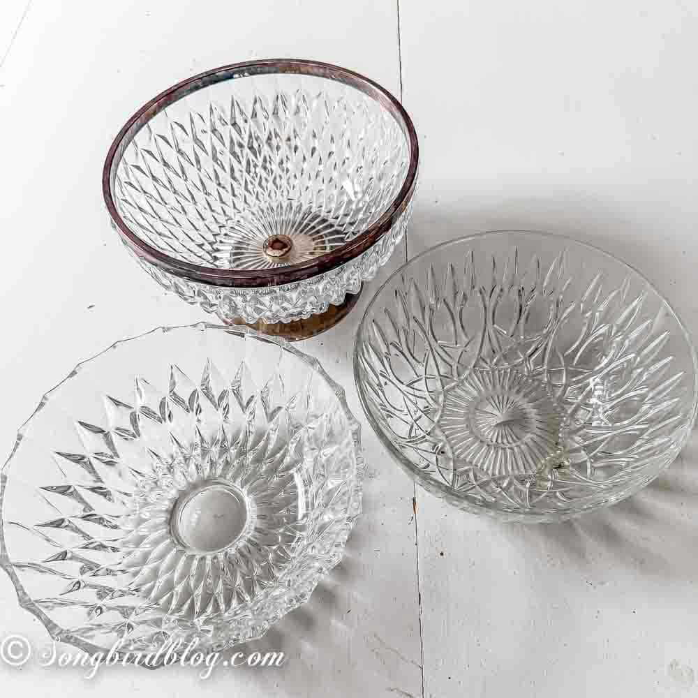 Thrift store crystal bowls standing on a white table.