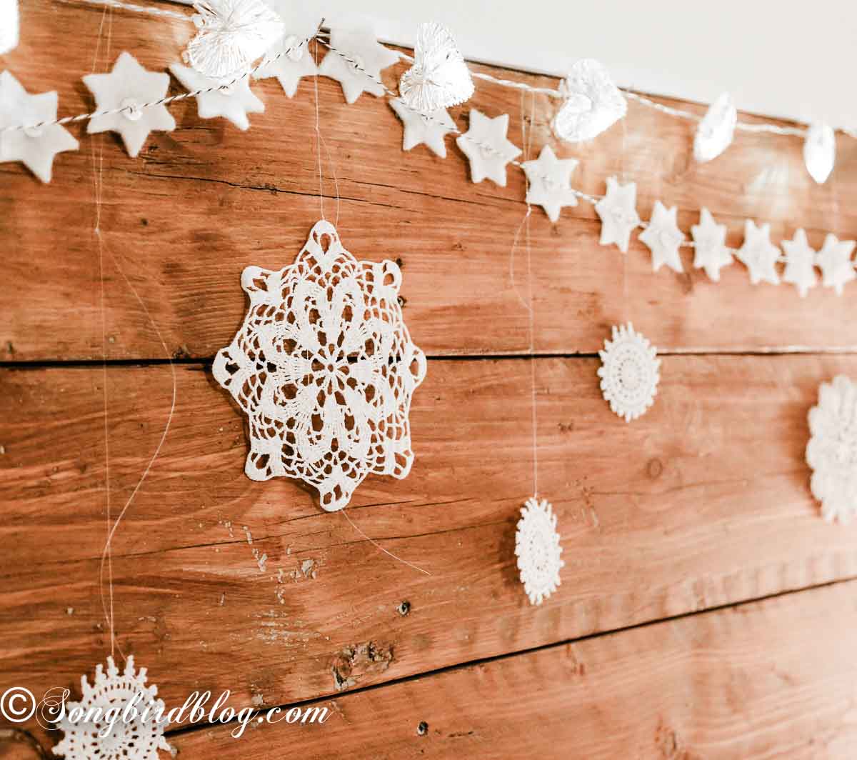 Wool felt garland draped along the top of a dark repurposed wood headboard.