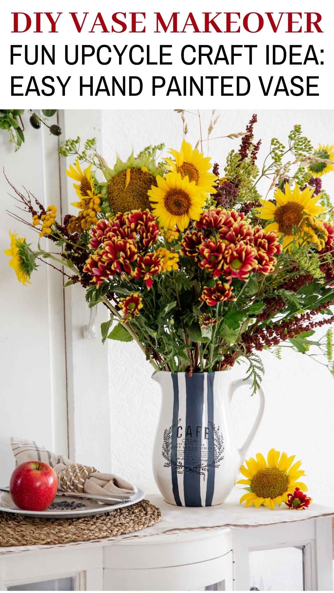 A hand painted vase with blue stripes and a vintage label transfer with a large bouquet of sunflowers and wild flowers. Text overlay: diy vase makeover - fun upcycle craft idea: easy hand painted vase.