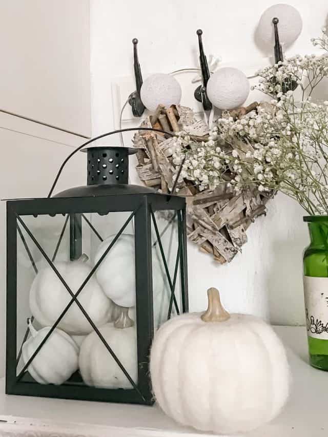 fall lantern decor with a black lantern filled with white pumpkins