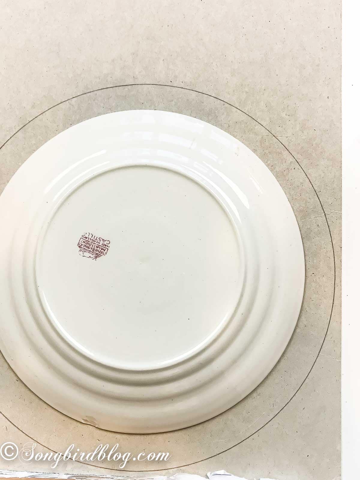 Tracing a dinner plate and lunch plate onto cardboard to cut a wreath base.