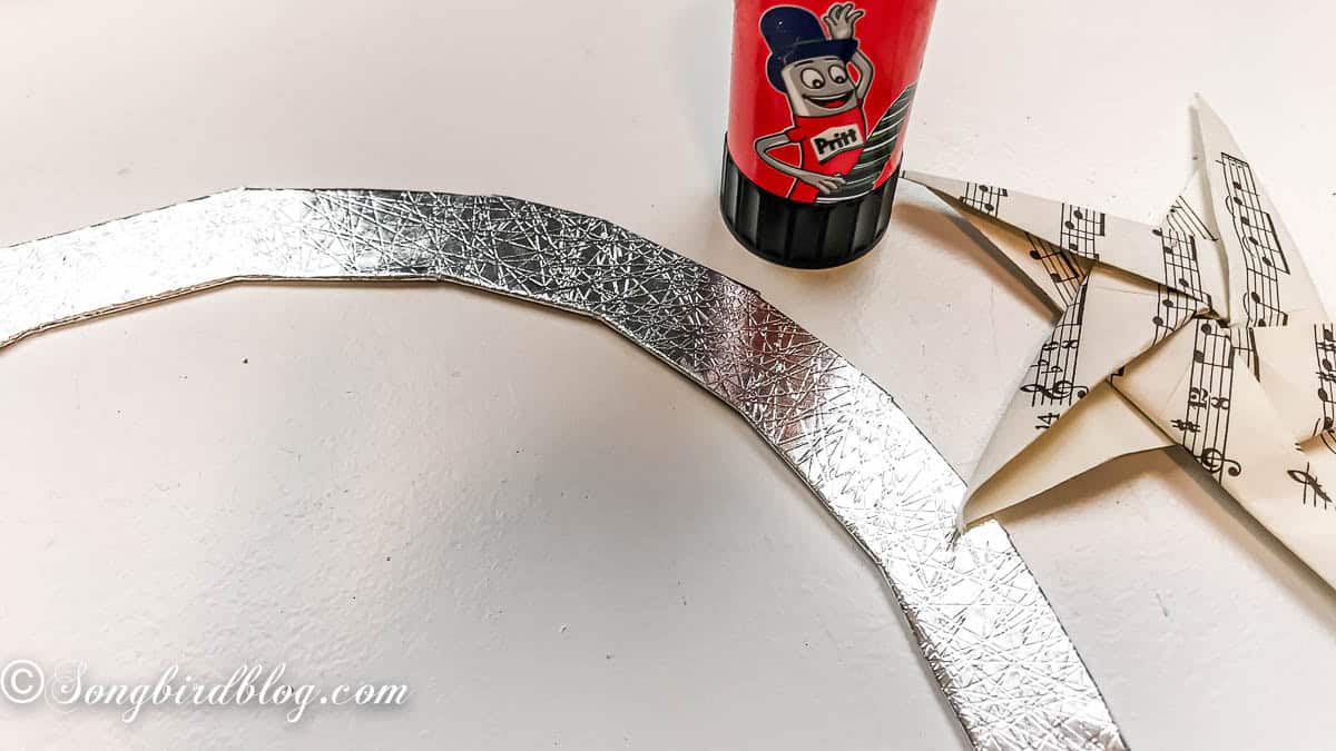 Cardboard wreath base covered in silver wrapping paper.