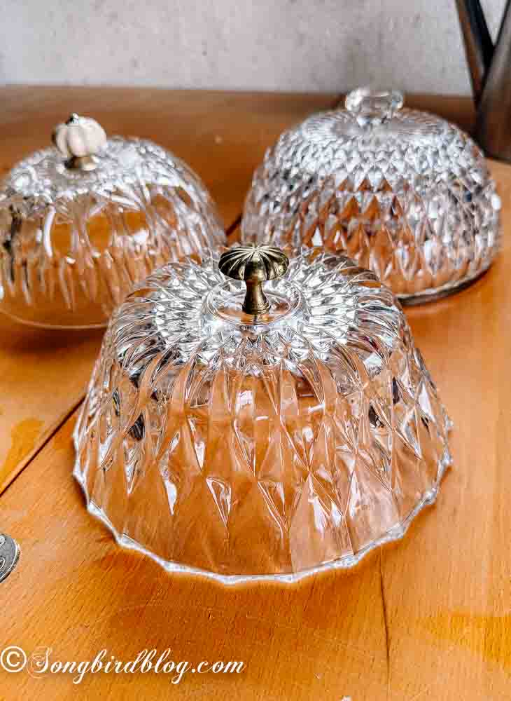 Three crystal bowls turned over with three different kind of drawer pulls attached to the top.