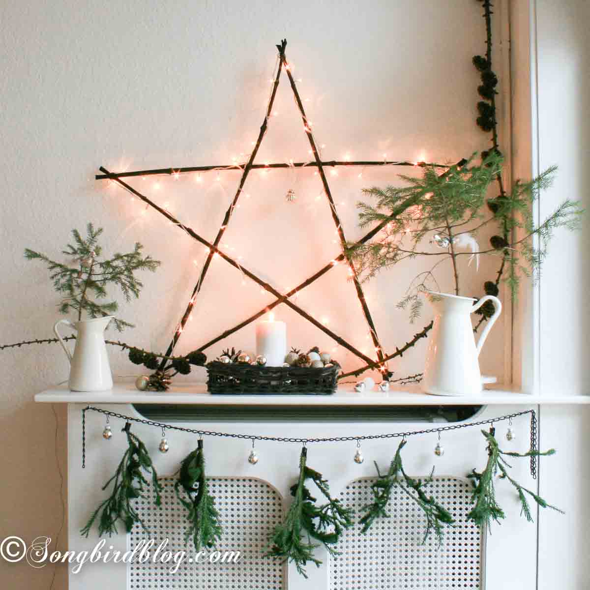 Rustic mantel with wooden star made from twigs and decorated with lights.