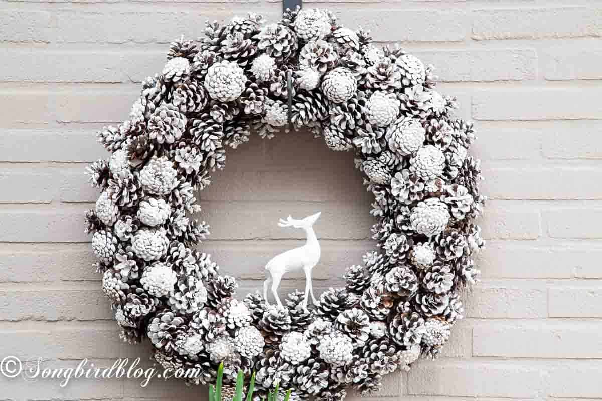 Oversized pinecone wreath frosted with white paint.