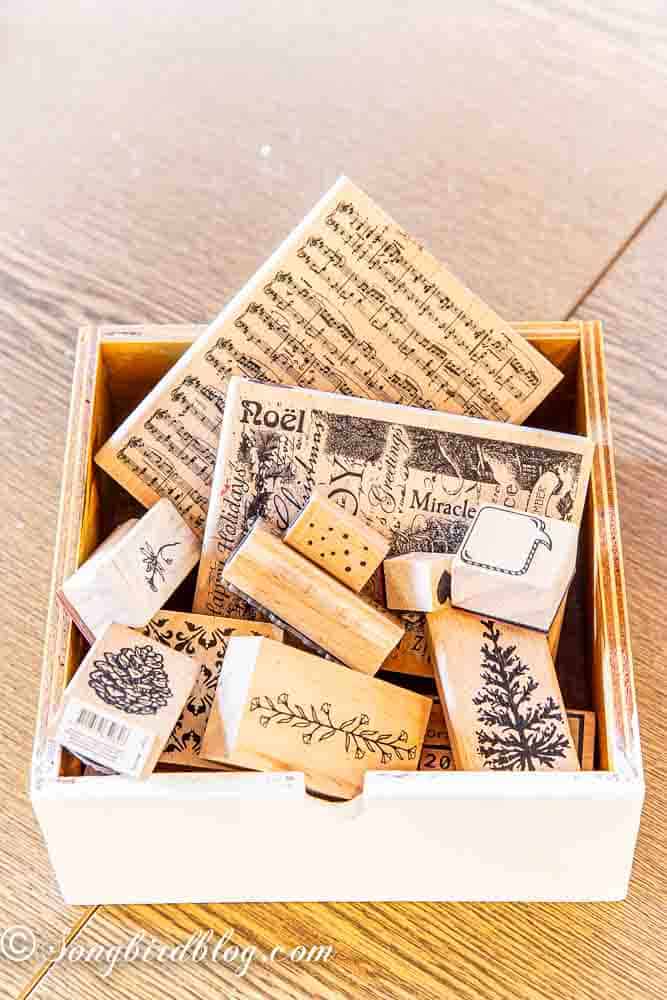 Collection of rubber stamps in a wooden box in a post about how to organize rubber stamps.