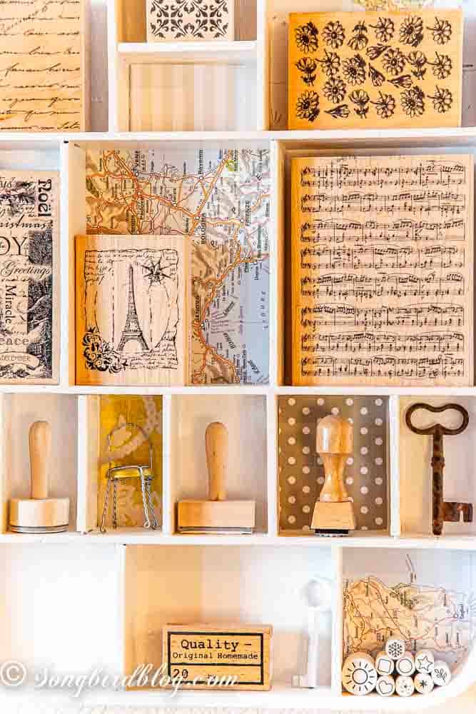 Rubber stamp storage idea showing wood mounted stamps neatly organized in white wooden printer trays.
