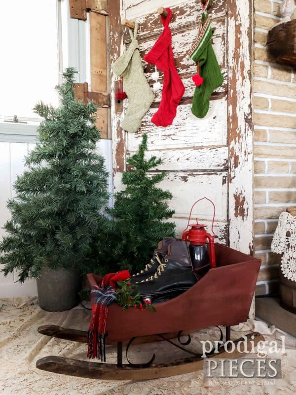 Outdoor Christmas decor with a wooden sleigh made from upcycled trash finds.